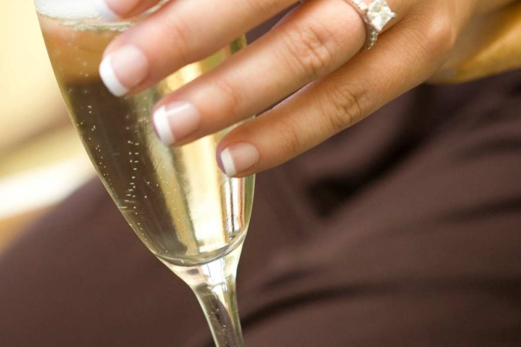 Holding a champagne glass from rim